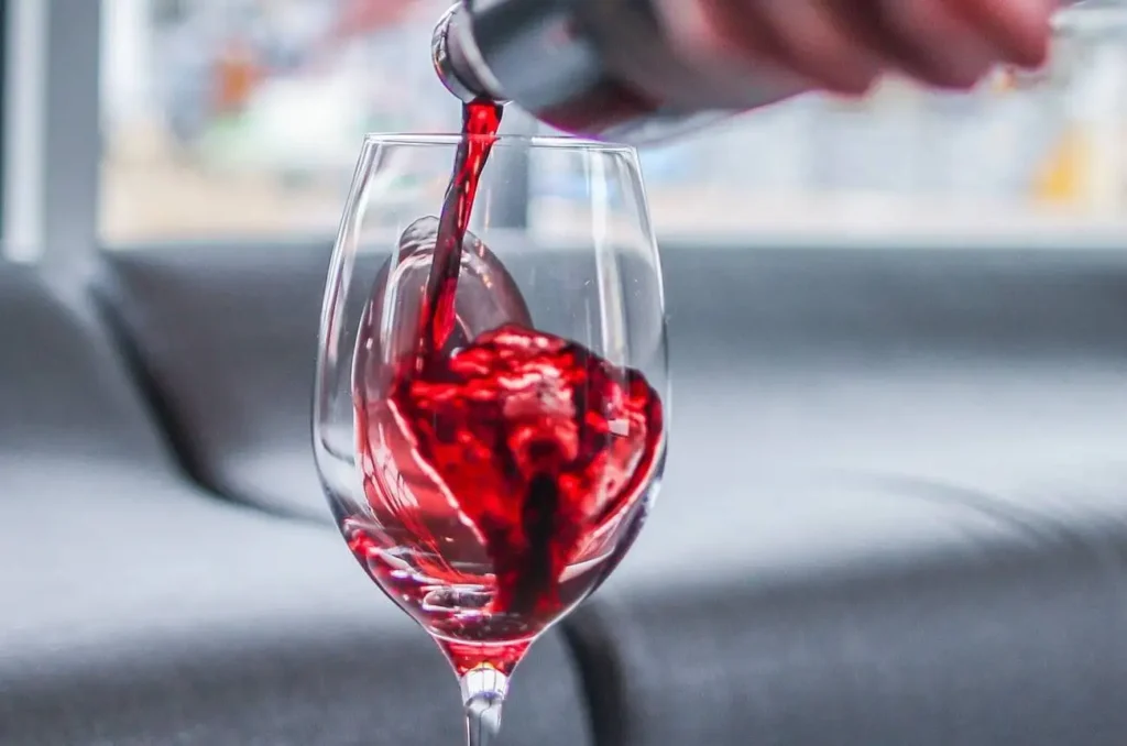 Premium red wine pouring into a glass for Lebanese Village restaurant drink and spirits menu.
