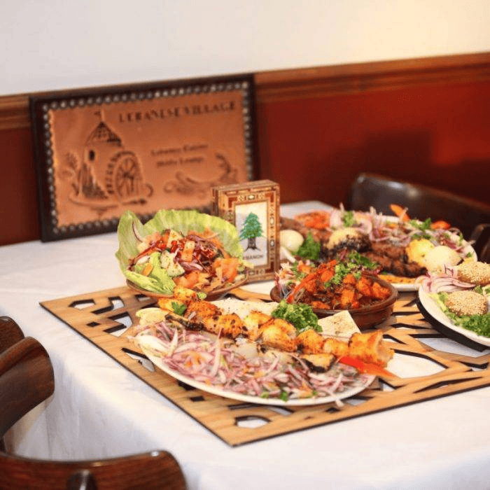 Lebanese Village restaurant feast spread featuring mixed grill skewers, mezze appetizers, and fresh salad.