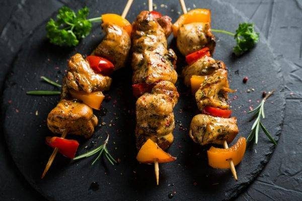 Lebanese grilled chicken shish taouk skewers served on a slate plate for Middle Eastern restaurant dining.